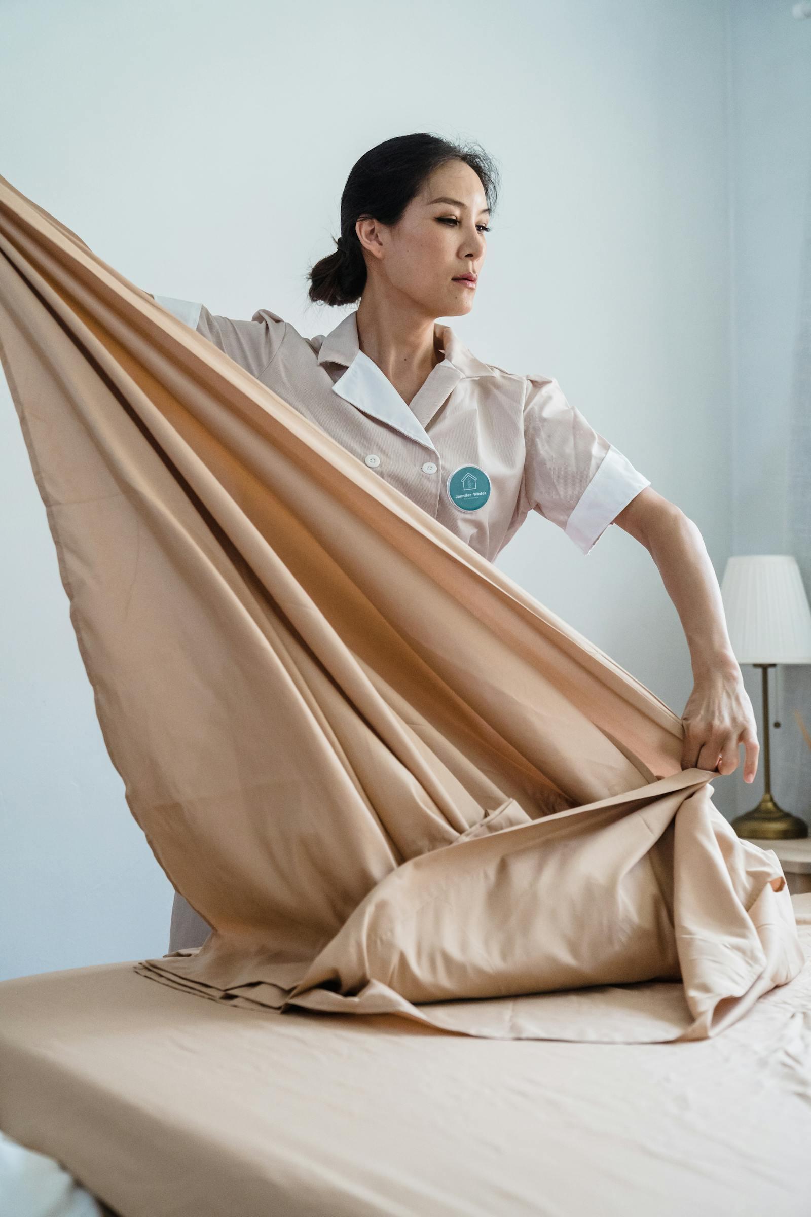 Housekeeping staff making a hotel bed